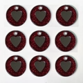 Macro shot of nine round glittery red pet ID tags with a metal heart and hole for DIY use - Red
