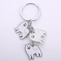 Dettaglio del portachiavi in metallo argento con tre ciondoli smaltati di cane Samoiedo - Samoiedo / 10cm