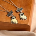Macro detail of best friend pug necklaces with enamel charms and engraved metal tags - Pug