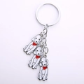 Detail shot of three silver metal poodle charms with red scarves on a sturdy key ring - Silver String Of Three Dogs