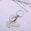 Silver metal keychain with white enamel cat charms and blue eyes on a desk background - 9cm / Persian Cat