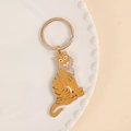 Golden tiger enamel keychain with orange stripes and metal ring on white tray - With Bone Charm / Tiger Shape Gold