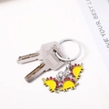 Porte-clés dinosaure jaune avec trois pendentifs stégosaure sur un anneau en métal - Dinosaure Jaune