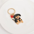Gouden sleutelhanger met schattige teckel hanger en een rode hartvormige decoratie - Gouden Ring Rennende Teckel met Rood Hart
