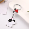 Gros plan d'un porte-clés chien mignon avec pendentif cœur rouge et anneau poli - Bichon Maltais avec Cœur Rouge