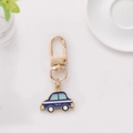Detailed view of creative blue taxi keychain with polished gold hardware on a clean white desk - Taxi