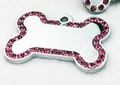 Makroaufnahme von knochenförmigem Edelstahl-Tieranhänger mit rosa Glitzersteinen - 41 Strasssteine Rosarot