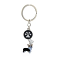 Detail showing a metal corgi keychain with paw print and bone pendants on white background - Black Corgi