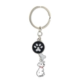 Silver metal keychain with spotted dog, paw print, and bone charms on white background - Dalmatian