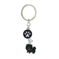 Detailed close-up of a metal pet keychain with paw print, bone, and dog charms - Black Chow Chow