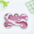 Roze camouflage hond penning in botvorm met zilveren frame op een frisse bloemen achtergrond - Roze