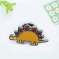 Détail du pin's dinosaure stégosaure jaune avec plaques rouges et fermoir papillon - Stégosaure de Dessin Animé Jaune et Rouge