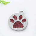 Detail eines runden silbernen Haustiermarke mit rotem Glitzerpfotenabdruck-Inlay - 2.5cm 5g / Rot