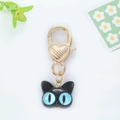 Close-up of black cat keychain with blue eyes and gold heart-shaped metal lobster clasp - Big Eye Cat Black