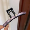 Dettaglio di un grande fermaglio per capelli in PVC nero con motivo a scacchi e perla - Scacchi Neri e Rosa
