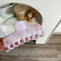 Close-up of a pink and white marble texture acetate shark hair claw clip in hand - Pink