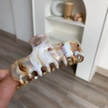 Detail view of the large marble patterned acetate hair claw clip with a polished finish - Caramel Texture