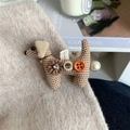 Dackel-Haarspange aus Karostoff mit Perlen und Glocken auf Tweed-Kleidung fixiert - Beige Karierter Hund Seitenclip