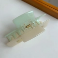 Detalle de una pinza para el cabello bicolor verde claro y crema con resorte dorado - Bloque de Color Verde y Beige