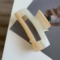 Détail de la pince à cheveux en acétate crème avec lettrage doré élégant gravé sur le côté - 10cm x 4,5cm
