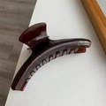 Detailansicht einer dunkelbraunen Harz-Haarklammer mit goldenem Barrette la France Schriftzug - Kaffee Bogen Haarklammer