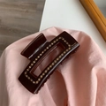 Detailed macro view of dark brown resin hair claw clip with rhinestones and gold lettering - Brown Geometric Rectangular Rhinestone Claw Clip