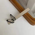Macro view of a creamy white butterfly hair clip with black butterfly wing patterns - Beige Single Butterfly Hair Clip