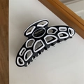 Détail d'une pince à cheveux noir et blanc avec lettrage doré Barrette La France - Noir et Blanc
