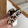 Détail d'une pince à cheveux en acétate avec motifs contrastés et ressort en métal - Blanc et Caramel