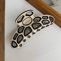 Détail d'une pince à cheveux en résine beige avec lignes géométriques et texte français - Beige et Noir Creux