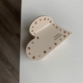 Detalle de pinza de pelo de corazón crema con diamantes de imitación y letras doradas - Blanco