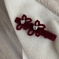 Dettaglio della clip per capelli in velluto bordeaux con cuore metallico e fiori di strass - Rosso