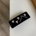 Detail einer schwarzen Haarspange mit rosa Herz-Strasssteinen und CD-Logo-Prägung - Federclips / Schwarzes Quadrat