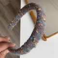 Vista dettagliata della morbida trama a maglia grigia e fibre di lana arcobaleno della fascia - Grigio