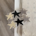 Détail de deux barrettes avec breloques étoiles sur fond en tissu beige texturé - Pince à Cheveux Étoile Noire