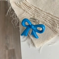 Close-up of a small cobalt blue bow hair claw clip with transparent base and metal spring - Blue