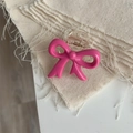 Detalle de una pinza para el pelo con lazo rosa brillante de resina sobre tela de lino - Rojo