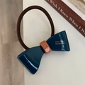 Detailed macro view of the navy blue ribbon bow hair tie with golden handmade lettering - Navy Blue