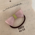 Detail of pink and green resin bow hair tie with handmade lettering on canvas background - Pink Hair Tie