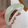 Detail of mint green crescent acetate hair claw with golden handmade logo lettering - Light Green
