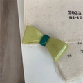 Détail d'une barrette à cheveux nœud vert menthe avec finition brillante et lettrage chic - Vert