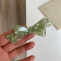 Details einer Haarspange mit grüner Marmorschleife aus Acetat und Goldgravur - Blaugrün