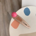 Detail van een pastelkleurige haarklem met een glanzende roze kraal en zachte matte finish - Rode Bal En Beige Grijs Clip