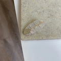Detalle de pinza ovalada con textura de nácar, rejilla dorada e incrustación metálica - Ovalado Blanco Sirena