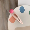 Detailopname van een roze metalen haarspeld met een magenta gekleurde bal - Rode Bal En Roze Clip