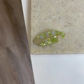 Detalle de una pinza para el pelo ovalada a cuadros con textura perlada y adorno dorado - Ovalado Verde