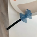 Détail d'une barrette à cheveux bleue en acétate avec nœud triple sur plateau blanc - Bleu