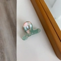 Détail de la mini pince à cheveux en acétate avec motif marbré coloré et design torsadé - 3,4 cm x 2,5 cm / Marbre Bleu Rose Clair
