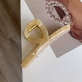 Detailopname van acetaat haarklem met crème marmeren textuur en France Handmade logo - Beige