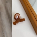 Gros plan d'une pince à cheveux en acétate marron avec texte Sunshine Handmade sur table - 3,4 cm x 2,5 cm / Couleur caramel